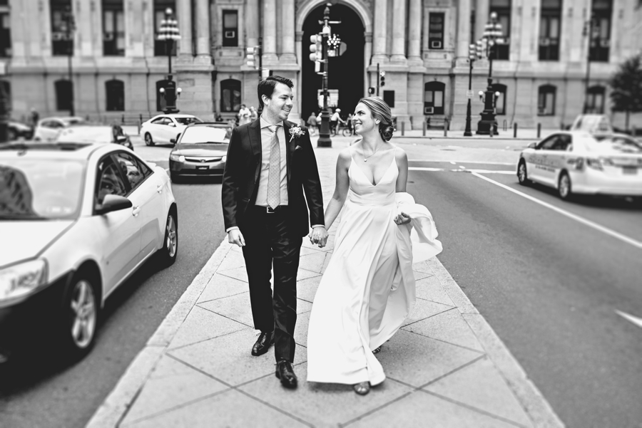 A married couple walk down the center of broad street in Philadelphia after their ceremony.